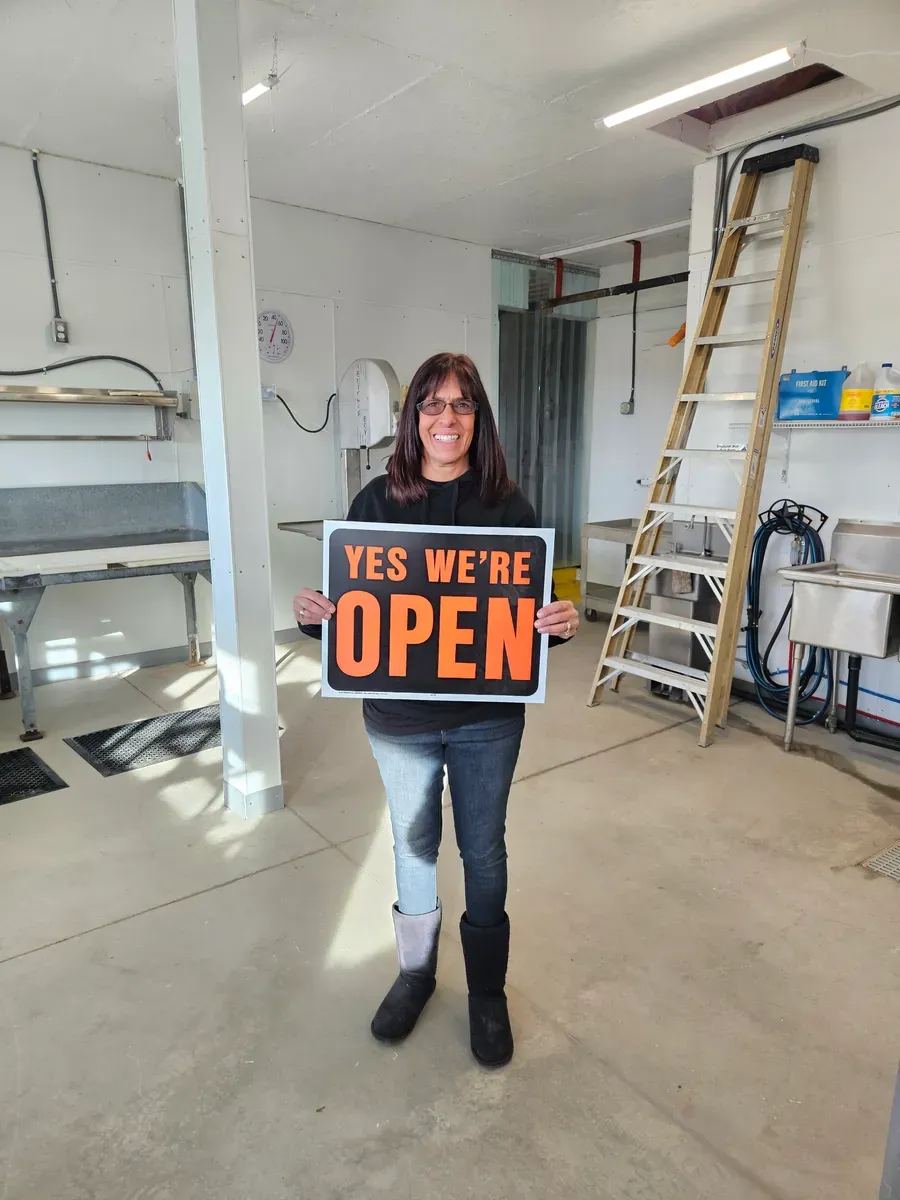 Mia Larson holding the Open sign