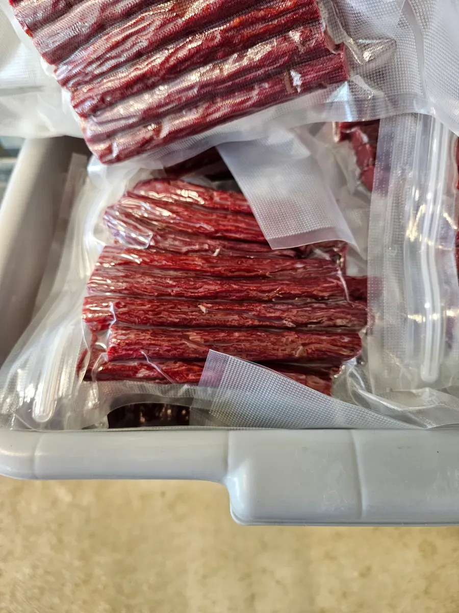 Vacuum-sealed packages of beef jerky and meat sticks ready for sale at H&M Custom Meat